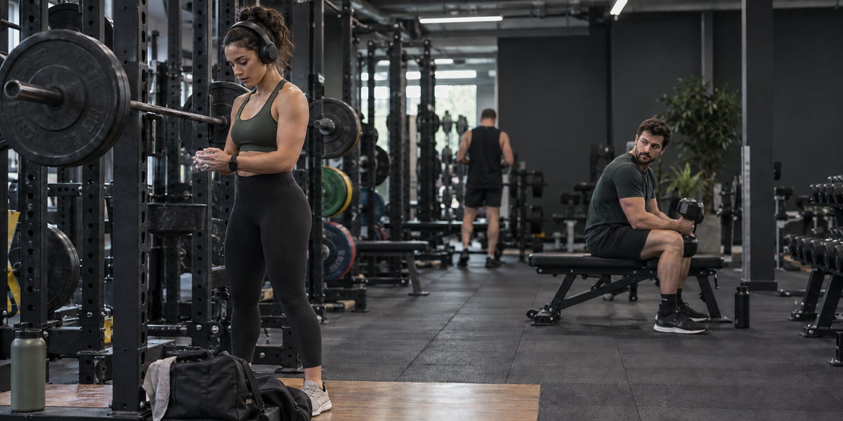 Woman training with headphones while another gym member respects her space